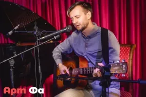 Взрослый ученик поёт с гитарой, закрыв глаза – Акустический вечер, октябрь 2023